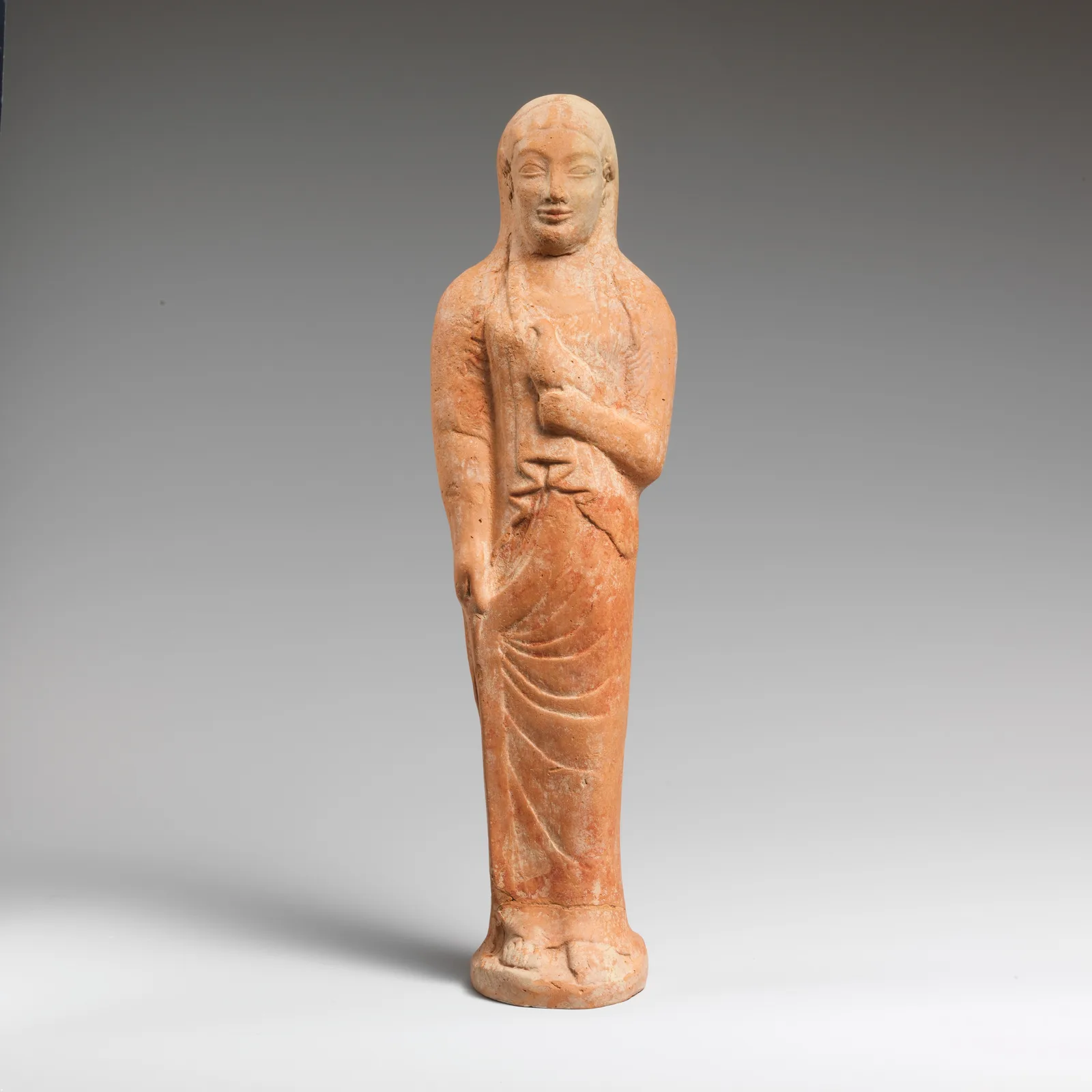 Terracotta statuette of a woman holding a bird